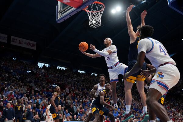 Kansas guard Dajuan Harris Jr. (3) puts up a shot during the first half of an NCAA college basketball game against West Virginia, Tuesday, Dec. 31, 2024, in Lawrence, Kan. (AP Photo/Charlie Riedel)