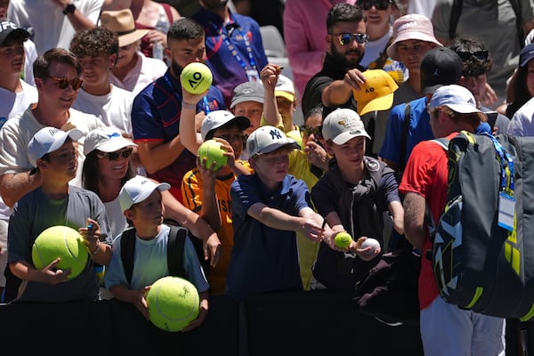 Alex Michelsen of the U.S. signs autographs after defeating Karen Khachanov of Russia in their third round match at the Australian Open tennis championship in Melbourne, Australia, Saturday, Jan. 18, 2025. (AP Photo/Ng Han Guan)