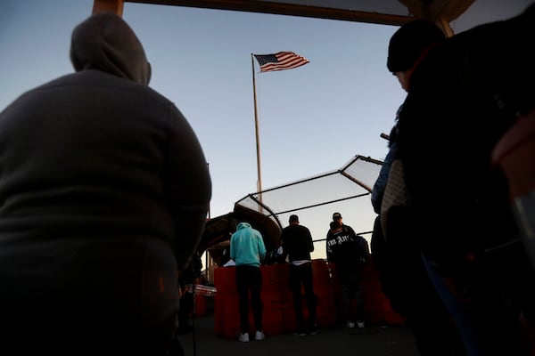 FILE - Migrants line up to present to U.S. agents, documents requesting an appointment to apply for asylum, at the Paso del Norte international bridge,in Ciudad Juarez, Mexico, Nov 5, 2024. (AP Photo/Christian Chavez, File)