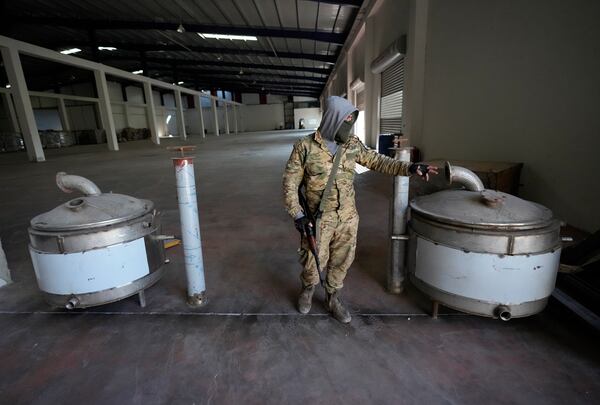 A Syrian member of the rebel group shows machines that were used to manufacturing amphetamine pills known as Captagon, at the warehouse where the drug was manufactured before the fall of Bashar Assad government at a facility in Douma city, outskirts of Damascus, Syria, Friday, Dec. 13, 2024. (AP Photo/Hussein Malla)