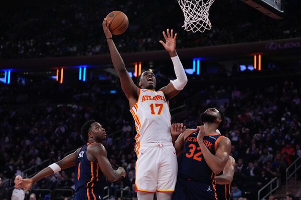 Atlanta Hawks' Onyeka Okongwu (17) shoots over New York Knicks' Karl-Anthony Towns (32) and OG Anunoby (8) during the first half of an Emirates NBA Cup basketball game Wednesday, Dec. 11, 2024, in New York. (AP Photo/Frank Franklin II)