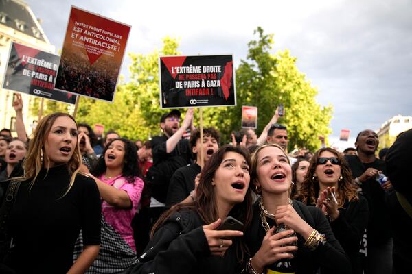 FILE - French voters react to the projected results of the second round of legislative elections, near Republique Plaza in Paris, July 7, 2024. (AP Photo/Christophe Ena, File)