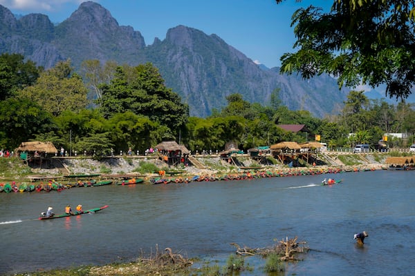 Foreign tourists ride on boat in a river in Vang Vieng, Laos, Friday, Nov. 22, 2024. (AP Photo/Anupam Nath)