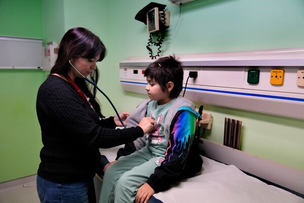 Doctor Dolly Noun, a pediatric hematologist and oncologist, checks Carol Zeghayer, 9, a girl who suffers from leukaemia ahead of her treatment at the Children's Cancer Center of Lebanon, in Beirut, Lebanon, Friday, Nov. 15, 2024. (AP Photo/Hussein Malla)