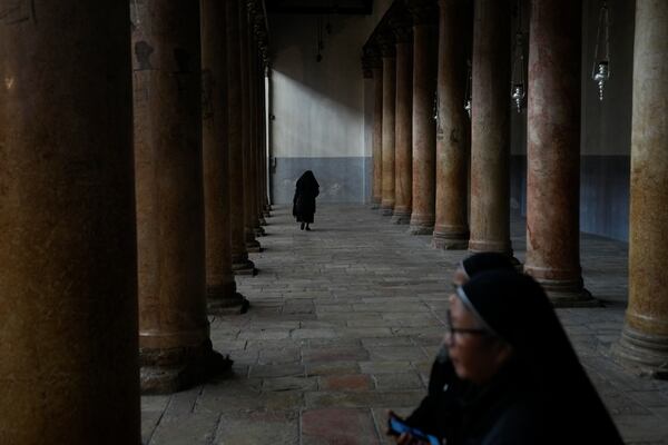 A worshipper walks through the Church of the Nativity, traditionally believed to be the birthplace of Jesus, on Christmas Eve, in the West Bank city of Bethlehem, Tuesday, Dec. 24, 2024. (AP Photo/Matias Delacroix)