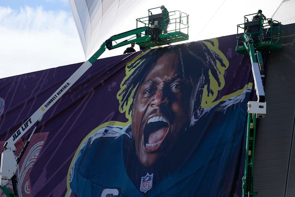 Workers hang player banners outside the Caesars Superdome, Saturday, Feb. 1, 2025, in New Orleans, prior to the NFL Super Bowl 59 football game between the Philadelphia Eagles and the Kansas City Chiefs. (AP Photo/Godofredo A. Vásquez)