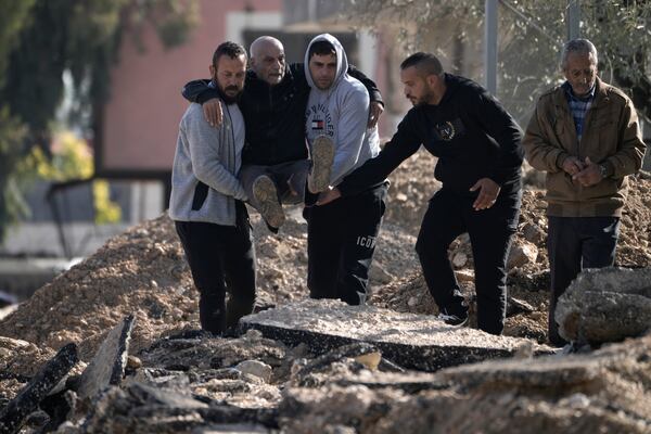 Palestinians displaced by an Israeli military operation evacuate from the Jenin refugee camp in the West Bank carrying an elderly man over rubble, on Thursday, Jan. 23, 2025. (AP Photo/Majdi Mohammed)