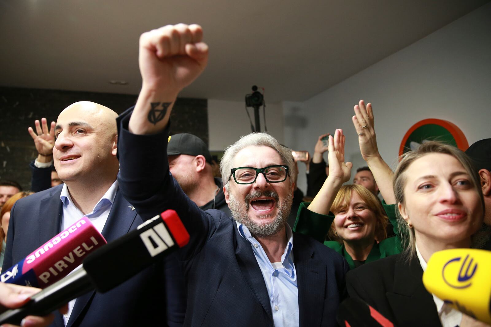 From left, Nika Melia and Nika Gvaramia, leaders of Coalition for Changes, and Nana Malashkhia, who leads the Coalition for Change parliament list, react while talking to journalists at coalition's headquarters after polls closing at the parliamentary election in Tbilisi, Georgia, Saturday, Oct. 26, 2024. (AP Photo/Zurab Tsertsvadze)