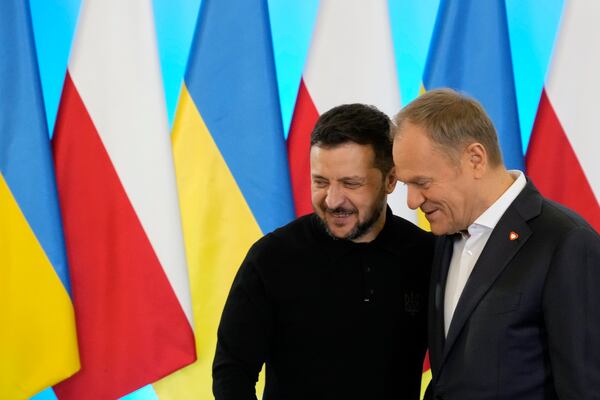 Polish Prime Minister Donald Tusk, right, welcomes Ukrainian President Volodymyr Zelenskyy after the two countries reached an agreement on a longstanding source of tensions between them: the exhumation of Polish victims of World War II-era massacres by Ukrainian nationalists, in Warsaw, Poland, on Wednesday, Jan. 15, 2025. (AP Photo/Czarek Sokolowski)