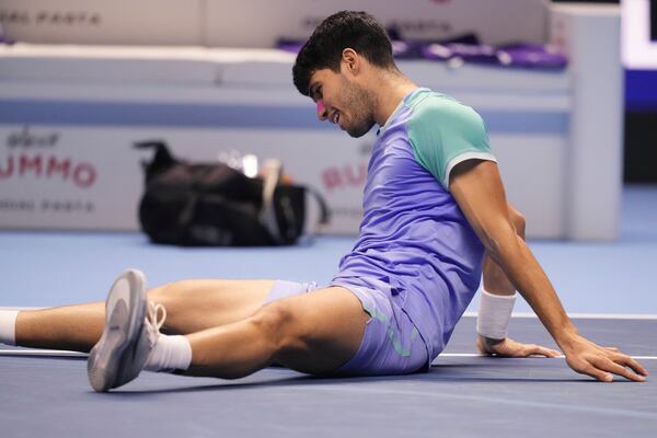 Spain's Carlos Alcaraz lies on the pitch during the singles tennis match of the ATP World Tour Finals against Germany's Alexander Zverev, at the Inalpi Arena, in Turin, Italy, Friday, Nov. 15, 2024. (AP Photo/Antonio Calanni)