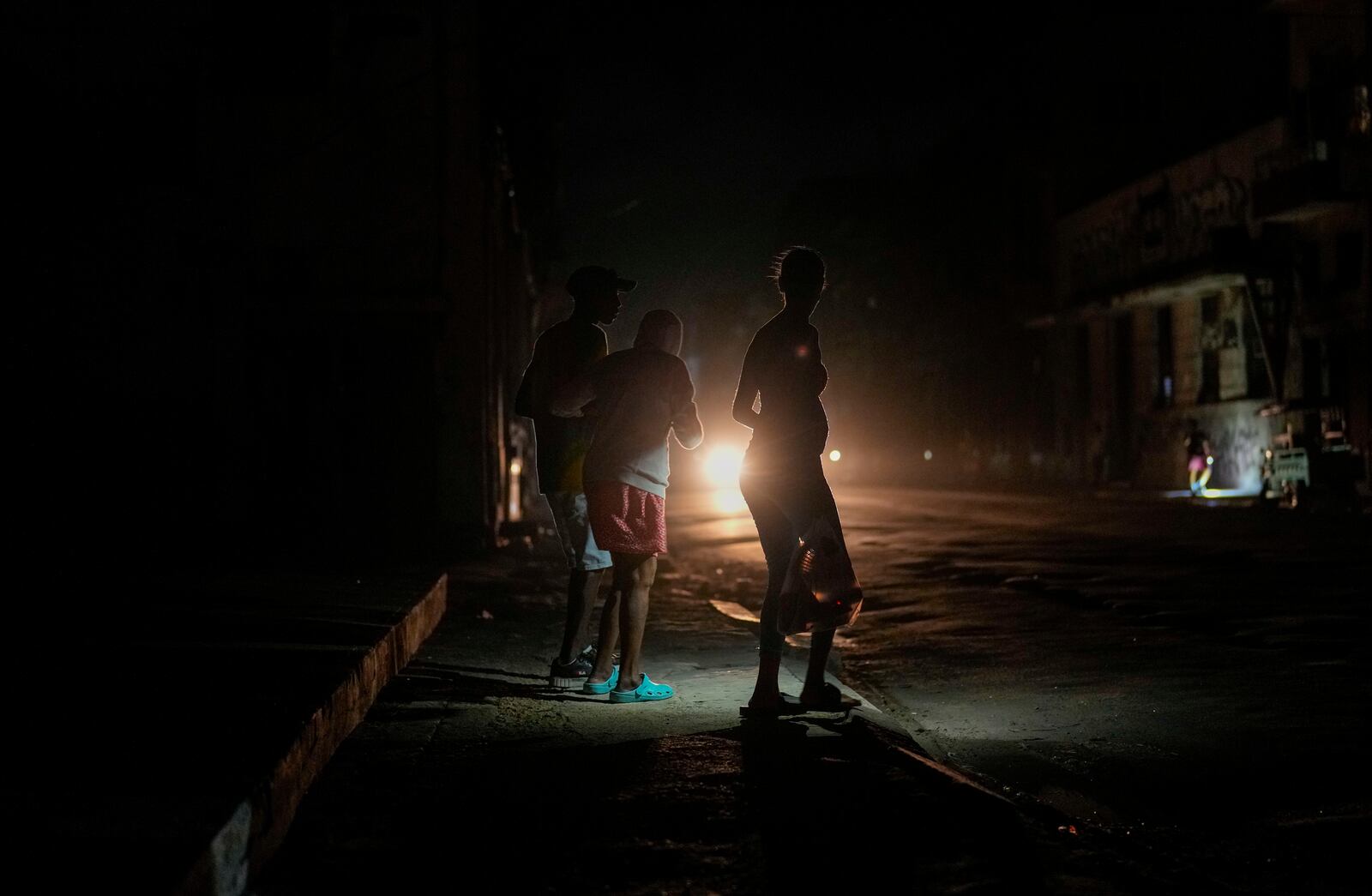 Residents walk on a street during a blackout following the failure of a major power plant in Havana, Cuba, Sunday, Oct. 20, 2024. (AP Photo/Ramon Espinosa)