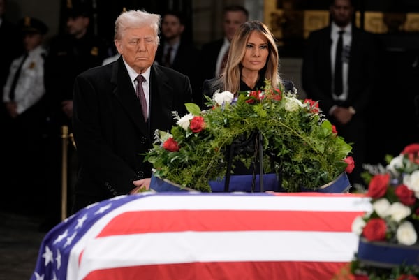 President-elect Donald Trump and Melania Trump pause at the flag-draped casket of former President Jimmy Carter as he lies in state in the rotunda of the U.S. Capitol in Washington, Wednesday, Jan. 8, 2025. (AP Photo/J. Scott Applewhite