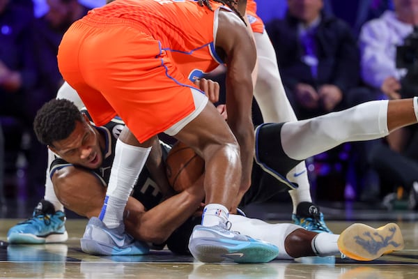 Milwaukee Bucks forward Giannis Antetokounmpo (34) wrestles for a loose ball with Oklahoma City Thunder guard Cason Wallace (22) during the first half of the championship game in the NBA Cup basketball tournament Tuesday, Dec. 17, 2024, in Las Vegas. (AP Photo/Ian Maule)