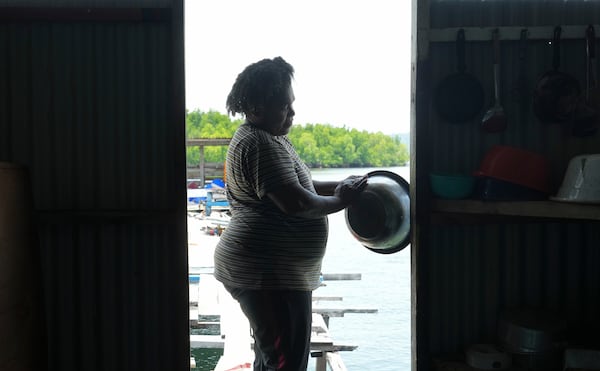 Petronela Merauje prepares to cook at her house at Enggros village in Jayapura, Papua province, Indonesia on Wednesday, Oct. 2, 2024. (AP Photo/Firdia Lisnawati)