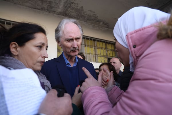 Geir Pederson, the United Nations' special envoy to Syria, center, listens to a woman who was looking for her missing relative in the Saydnaya prison, during his visit to the infamous Saydnaya military prison, in Saydnaya north of Damascus, Syria, Monday, Dec. 16, 2024. (AP Photo/Omar Albam)