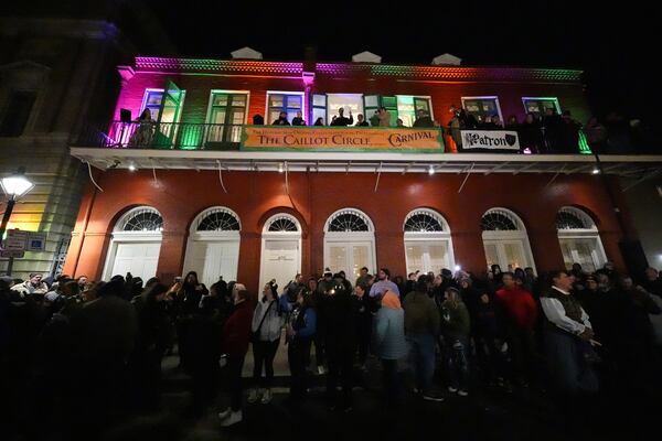 Parade attendees toast to victims of the deadly New Years truck attack, during the annual Krewe de Jeanne d'Arc parade, kicking off the Mardi Gras season, in New Orleans, Monday, Jan. 6, 2025. (AP Photo/Gerald Herbert)