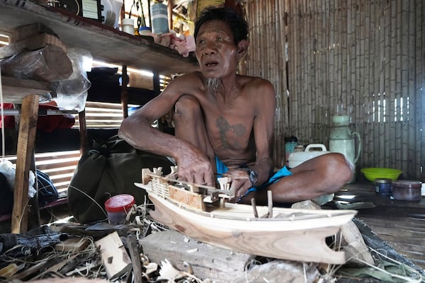 Tat Klathale makes a Kabang boat model for tourists to buy at Surin Islands in Phang Nga Province, Thailand, Thursday, Dec. 12, 2024. (AP Photo/Sakchai Lalit)