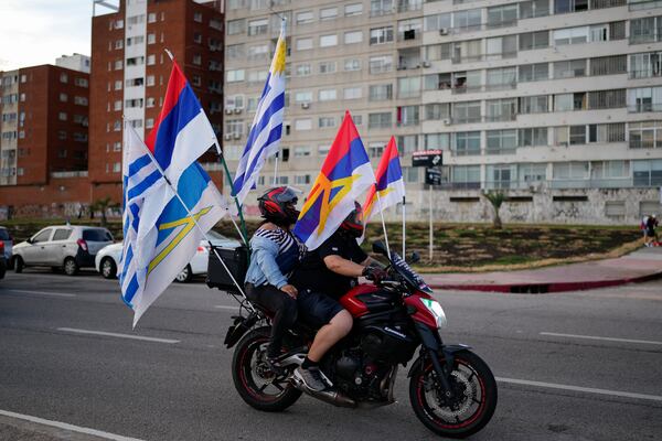 Supporters of Yamandu Orsi, candidate for the Broad Front (Frente Amplio), ride after polls closed in the presidential run-off election in Montevideo, Uruguay, Sunday, Nov. 24, 2024. (AP Photo/Natacha Pisarenko)