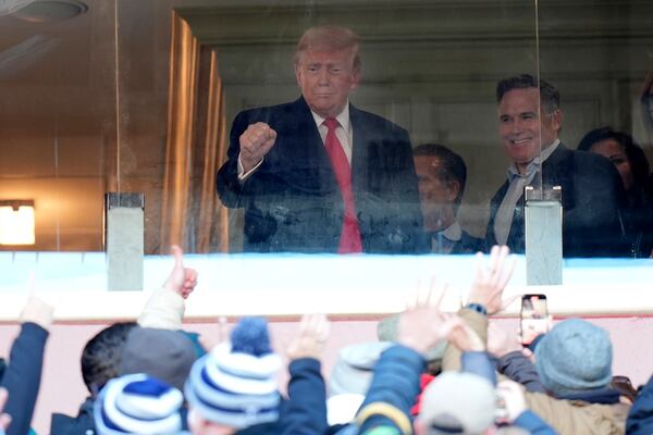 President-elect Donald Trump, left, joined by Senator-elect Dave McCormick, R-Pa., gestures to the crowd as he attends the NCAA college football game between Army and Navy at Northwest Stadium in Landover, Md., Saturday, Dec. 14, 2024. (AP Photo/Stephanie Scarbrough)