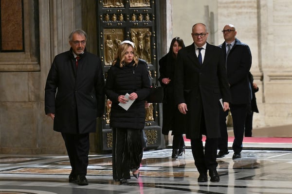 Italy's Prime Minister Giorgia Meloni, center, and Rome's Mayor Roberto Gualtieri, right, pass through after Pope Francis opened the Holy Door to mark the opening of the 2025 Catholic Holy Year, or Jubilee, in St. Peter's Basilica, at the Vatican, Tuesday Dec. 24, 2024. (Alberto Pizzoli/Pool via AP)