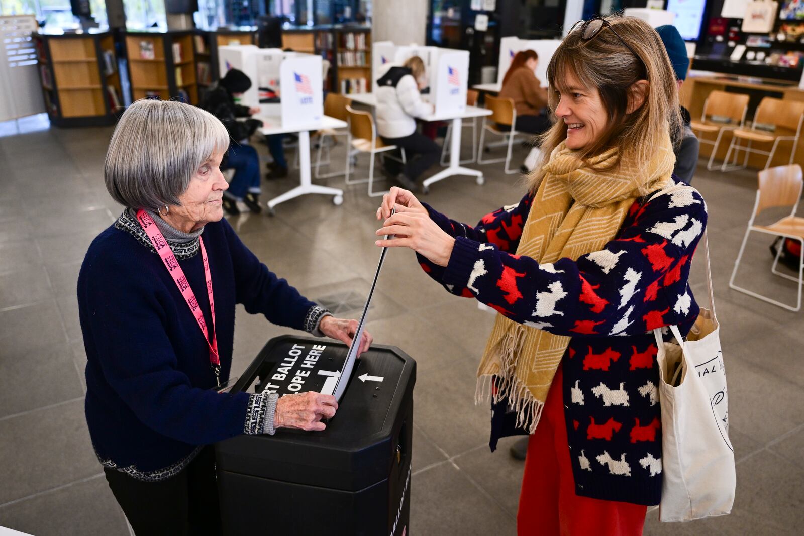 Kirsten Kearse, right, casts her ballot at the Missoula Public Library in Missoula, Mont., on Election Day, Tuesday, Nov. 5, 2024. (AP Photo/Tommy Martino)