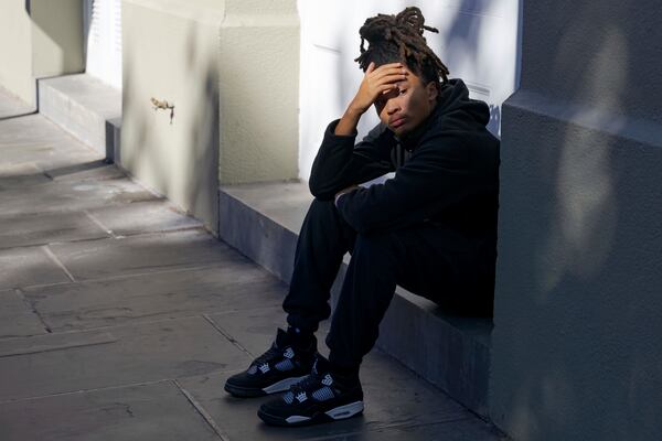 Trevant Hayes, 20, sits in the French Quarter after the death of his friend, Nikyra Dedeaux, 18, after a pickup truck crashed into pedestrians on Bourbon Street followed by a shooting in the French Quarter in New Orleans, Wednesday, Jan. 1, 2025. (AP Photo/Matthew Hinton)