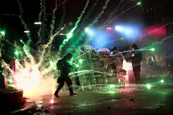 Demonstrators use petard against police as police blocked a street to prevent protesters rallying against the governments' decision to suspend negotiations on joining the European Union for four years, outside the parliament's building in Tbilisi, Georgia, early Saturday, Nov. 30, 2024. (AP Photo/Zurab Tsertsvadze)