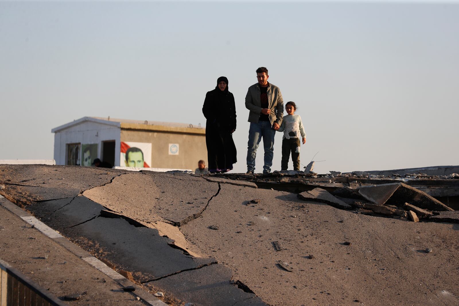 Syrian citizens observe a bridge that links to Lebanon which was destroyed on Oct. 24 by an Israeli airstrike, in Qusair, Syria, Sunday, Oct. 27, 2024. (AP Photo/Omar Sanadiki)