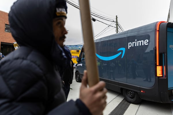 Amazon workers and members of the International Brotherhood of Teamsters picket in front of the Amazon fulfillment center in the Queens borough of New York, Friday, Dec. 20, 2024. (AP Photo/Stefan Jeremiah)