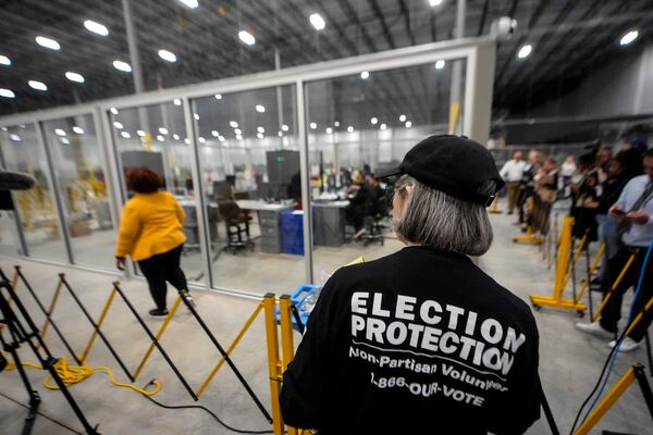 FILE - A non-partisan election volunteer observes as memory cards are uploaded from early voting at the Fulton County Election Hub and Operation Center, Nov. 5, 2024, in Atlanta, Mo. (AP Photo/John Bazemore, File)