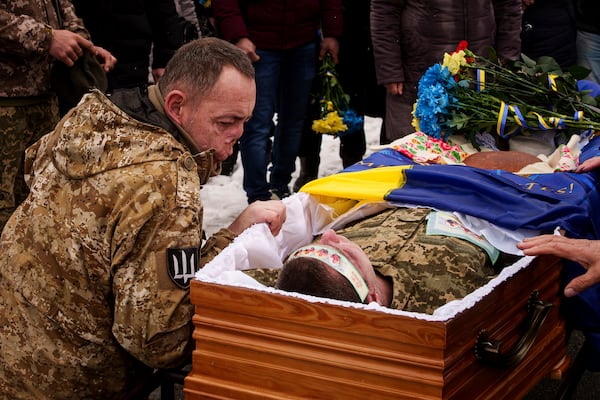 Ukrainian serviceman Roman bids farewell to his comrade of the 47th brigade Serhii Solovyov who was killed during fighting with Russian Forces in Kursk oblast on November 12, during the funeral ceremony in Irpin, Kyiv region, Ukraine, Nov. 21, 2024. (AP Photo/Evgeniy Maloletka)