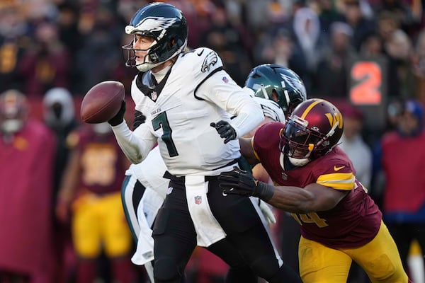 Philadelphia Eagles quarterback Kenny Pickett (7) avoids a tackle by Washington Commanders linebacker Bobby Wagner (54) during the second half of an NFL football game, Sunday, Dec. 22, 2024, in Landover, Md. (AP Photo/Stephanie Scarbrough)