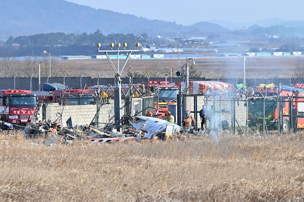 Firefighters and rescue team members work at Muan International Airport in Muan, South Korea, Sunday, Dec. 29, 2024. (Lee Young-ju/Newsis via AP)