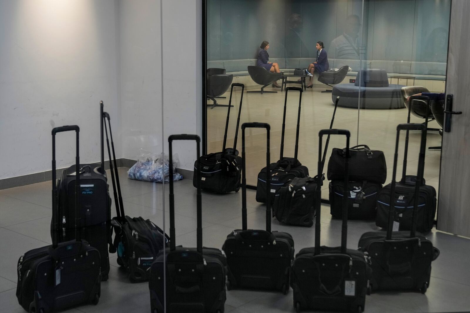 Middle East Airlines hostesses wait for their flights in the operations room at the MEA headquarter in Beirut, Tuesday, Oct. 22, 2024. (AP Photo/Bilal Hussein)