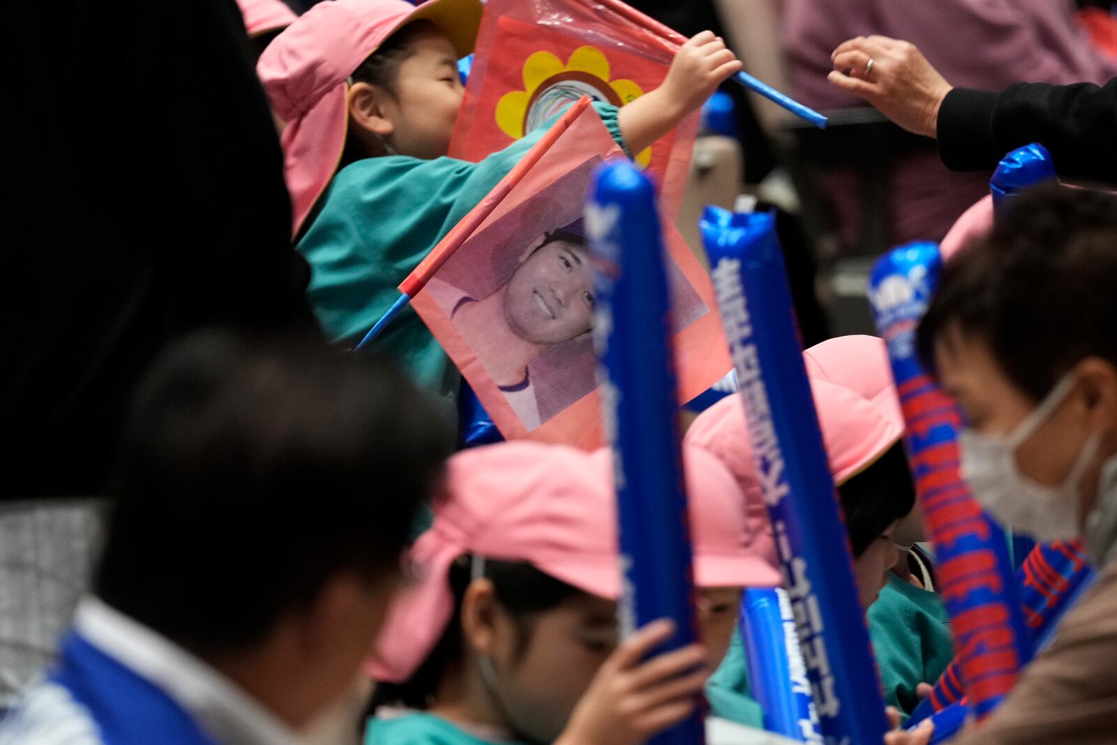 Kindergarteners holding a picture of Shohei Ohtani of the Los Angeles Dodgers watch a live stream before the start of Game 3 of the baseball World Series between the Dodgers and the New York Yankees during a public viewing event in Oshu, northeastern Japan, the hometown of Ohtani, Tuesday, Oct. 29, 2024. (AP Photo/Eugene Hoshiko)