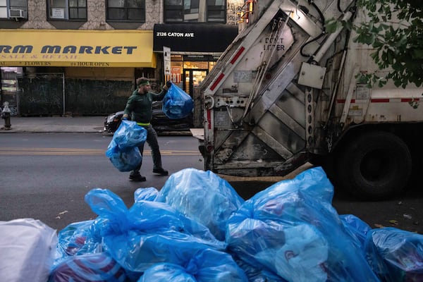 A sanitation worker collects trash, Saturday, Nov. 16, 2024, in the Brooklyn borough of New York. (AP Photo/Yuki Iwamura)