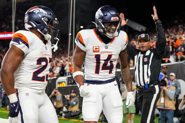 Denver Broncos wide receiver Courtland Sutton (14) celebrates a touchdown with running back Audric Estime (23) against the Cincinnati Bengals during the second half of an NFL football game in Cincinnati, Saturday, Dec. 28, 2024. (AP Photo/Jeff Dean)