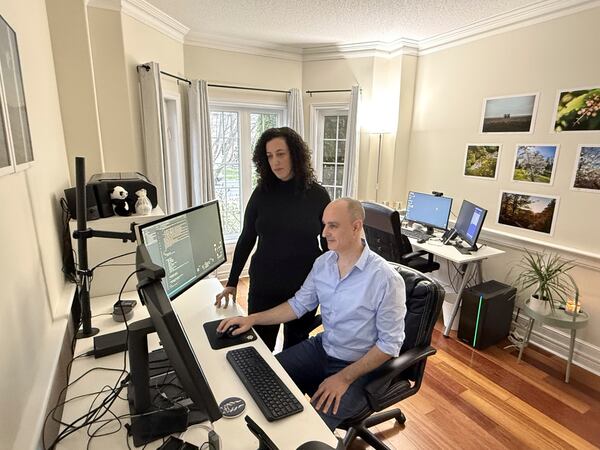 Michal Harel and her husband Avital Epstein show the website they set up to help Israelis navigate a move to Canada in Oakville, Ontario, Canada, Wednesday, Dec. 4, 2024. (AP Photo/Rob Gillies)