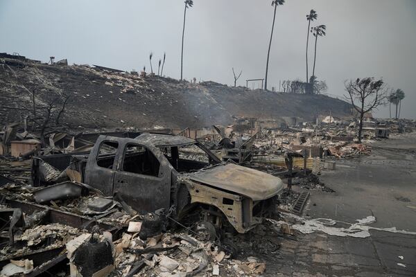 A vehicle and other structures are burned as the Palisades Fire ravages a neighborhood amid high winds in the Pacific Palisades neighborhood of Los Angeles, Wednesday, Jan. 8, 2025. (AP Photo/Damian Dovarganes)