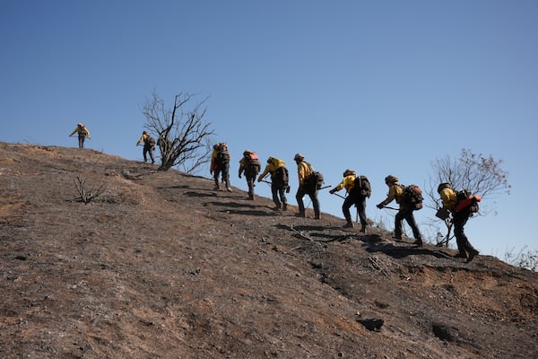 Fire crews work the burn zone of the Palisades Fire in Mandeville Canyon Thursday, Jan. 16, 2025, in Los Angeles. (AP Photo/Jae C. Hong)