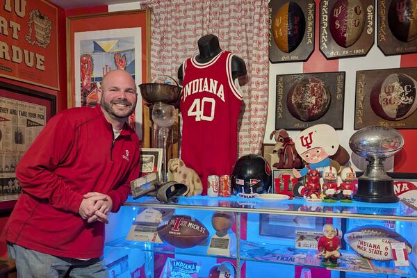 In this photo provided by Heather White, Indiana Hoosiers fan Brett White pose Monday, Dec. 16, 2024, at his home in Bloomington, Ind. White and other Indiana fans are riding the euphoria of a great season that culminated in a berth in the College Football Playoff. The Hoosiers will meet Notre Dame on Friday night in South Bend, Ind. (Heather White via AP)