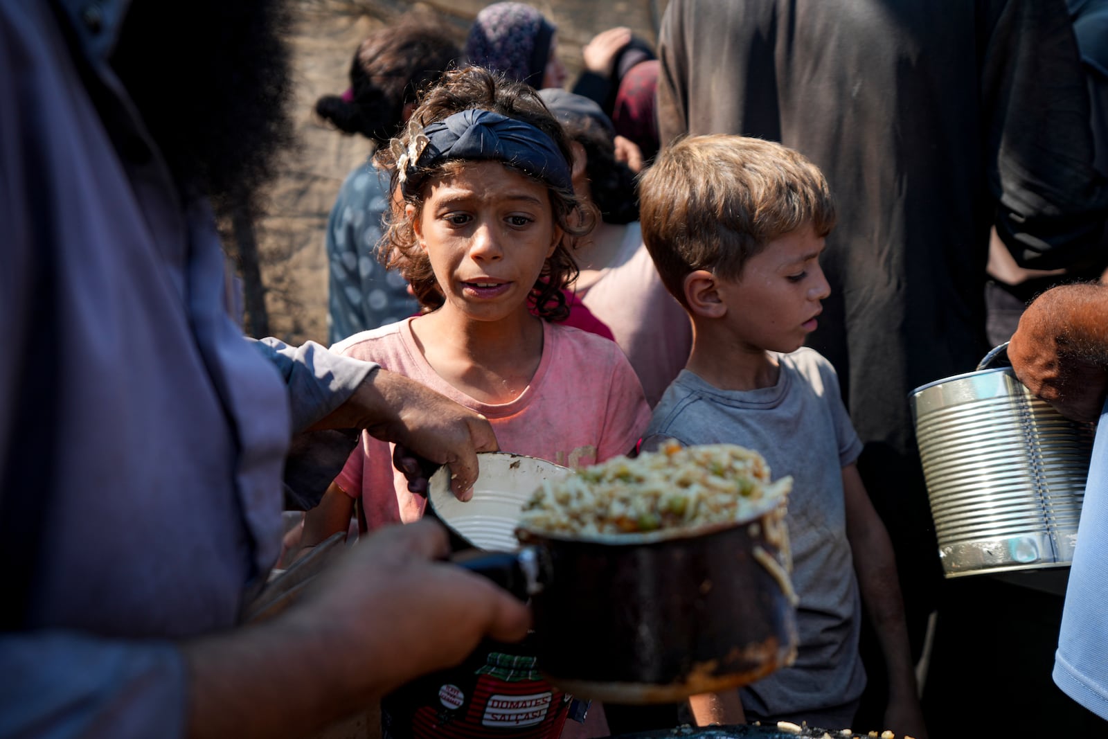 Palestinians line up for food distribution in Deir al-Balah, Gaza Strip, Thursday, Oct. 17, 2024. (AP Photo/Abdel Kareem Hana)