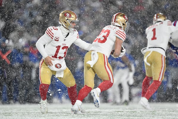 San Francisco 49ers quarterback Brock Purdy (13) hands off to running back Christian McCaffrey during the first half of an NFL football game against the Buffalo Bills in Orchard Park, N.Y., Sunday, Dec. 1, 2024. (AP Photo/Adrian Kraus)