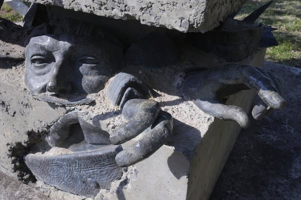 Pieces of a statue of dictator Gen. Alfredo Stroessner form part of a monument by late artist Carlos Colombino at Missing People's Square in Asuncion, Paraguay, Tuesday, Oct. 29, 2024. (AP Photo/Jorge Saenz)