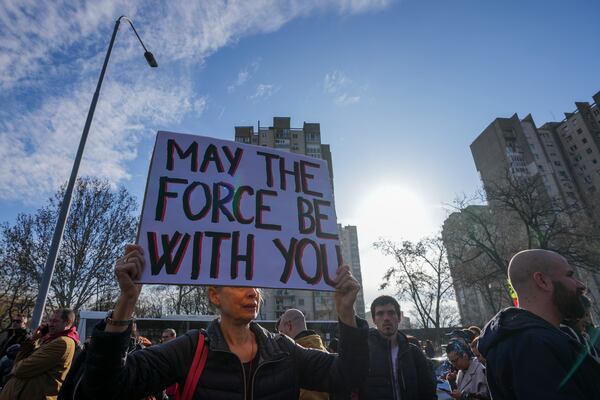 People greet students marching towards the northern city of Novi Sad, where they will participate in a 24 hour block of three bridges to protest the deaths of 15 people killed in the November collapse of a train station canopy, in Belgrade, Serbia, Thursday, Jan. 30, 2025. (AP Photo/Darko Vojinovic)