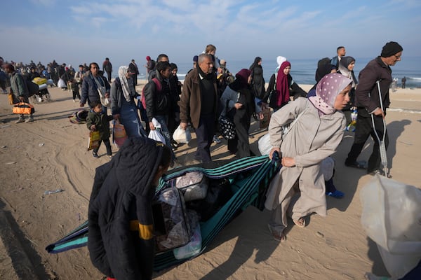 Carrying their belongings displaced Palestinians walk on a road to return to their homes in the northern Gaza Strip, Tuesday, Jan. 28, 2025, after Israel's decision to allow thousands of them to go back for the first time since the early weeks of the 15-month war with Hamas. (AP Photo/Abdel Kareem Hana)