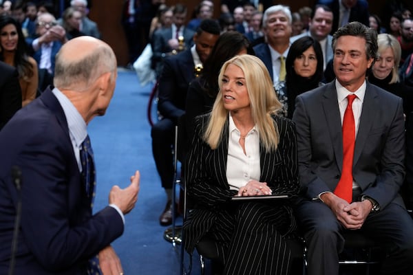 Sen. Rick Scott, R-Fla.,, left, talks with Pam Bondi, President-elect Donald Trump's choice to lead the Justice Department as attorney general and her partner John Wakefield before the Senate Judiciary Committee for her confirmation hearing, at the Capitol in Washington, Wednesday, Jan. 15, 2025. (AP Photo/Ben Curtis)