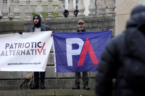 Protesters hold banners near Liverpool Crown Court in Liverpool, England, Monday, Jan. 20, 2025 where Axel Rudakubana is charged with killing three girls and wounding 10 other people in a stabbing rampage at a Taylor Swift-themed dance class in England last summer.(AP Photo/Jon Super)