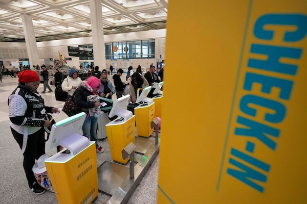 Passengers check-in for their flights at George Bush Intercontinental Airport Monday, Jan. 20, 2025, in Houston, ahead of a winter storm that will close both of Houston's airports Tuesday. (AP Photo/David J. Phillip))