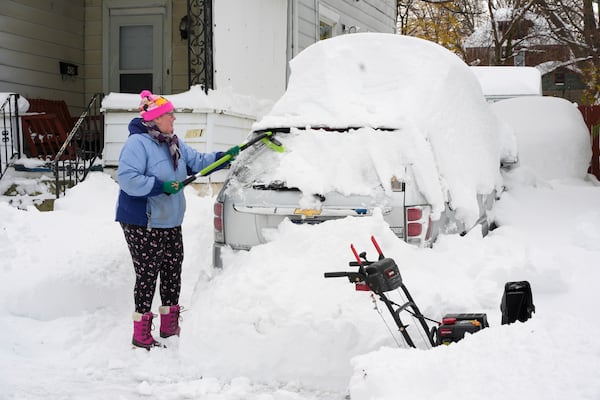 Serena Schodt brushes snow off her car in Erie, Pa., Monday, Dec 2, 2024. AP Photo/Gene J. Puskar)